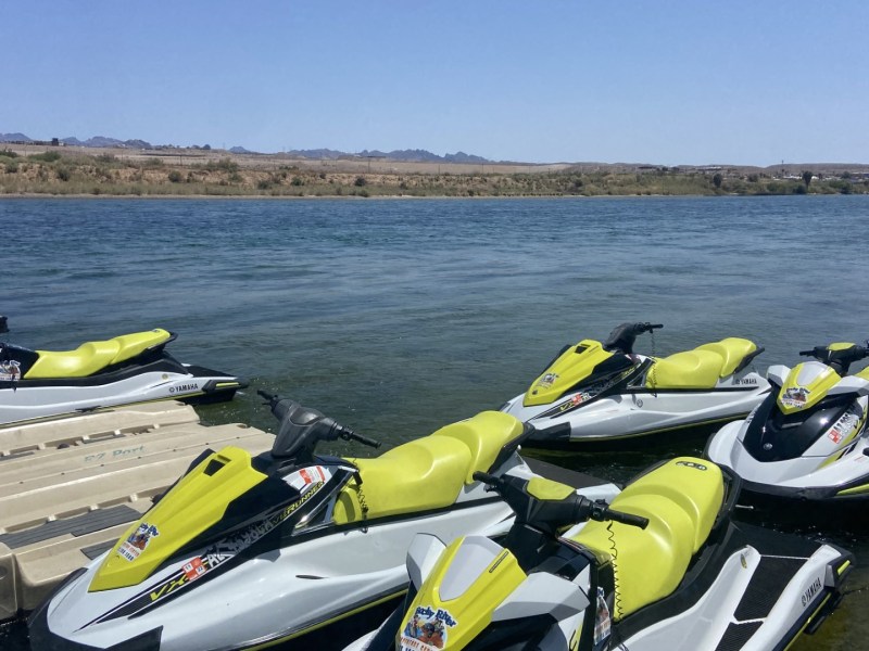 a row of parked motorcycles sitting next to a body of water