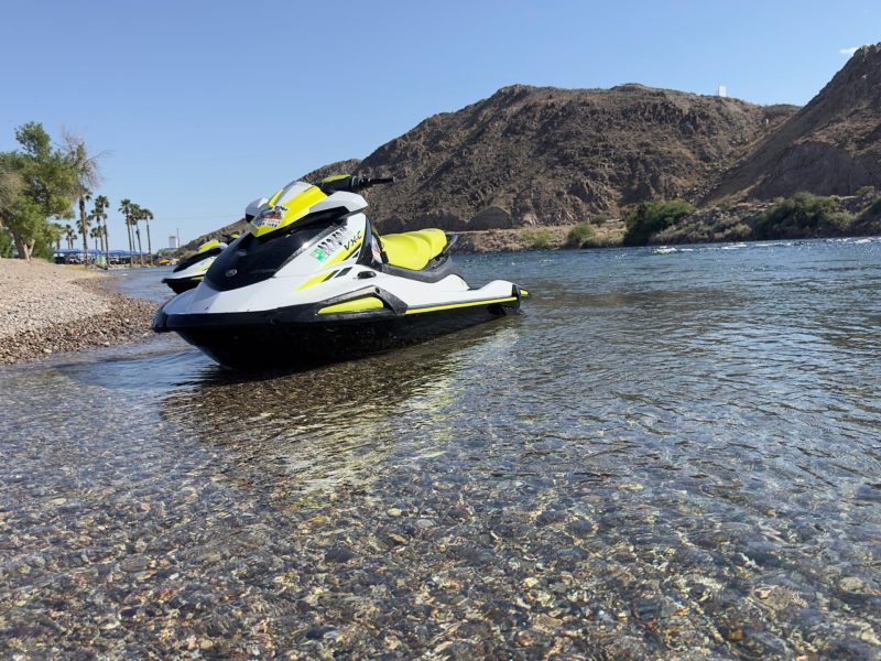 a small boat in a body of water with a mountain in the background
