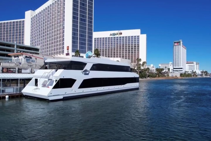 a large boat in a body of water with a city in the background