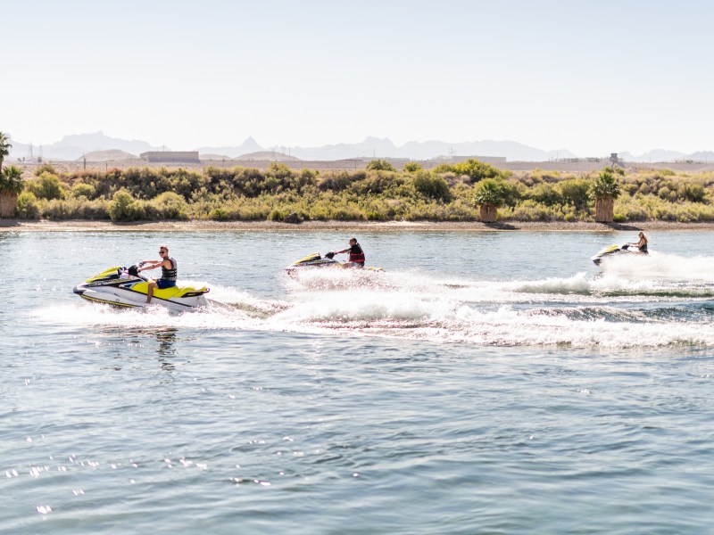 a group of people riding on the back of a boat in the water