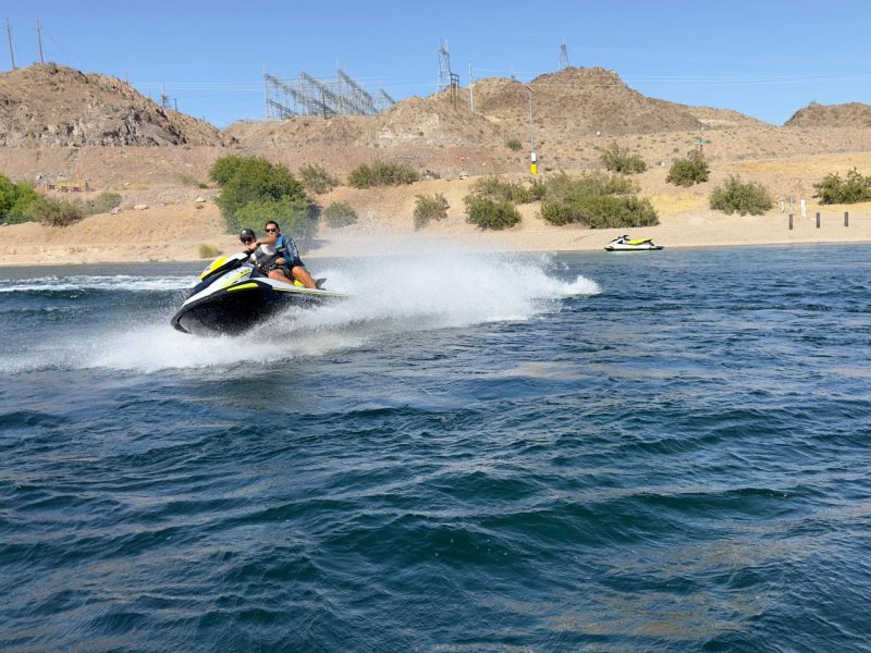 a man riding on the back of a boat in a body of water